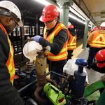 Workers prime a pump to empty the flooded Lincoln Center subway station, in New York, . A water main break flooded streets on Manhattan's Upper West Side near Lincoln Center and hampered subway service during the Monday morning rush hour